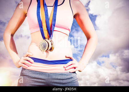 Image composite de portrait de femme sportive médailles holding poitrine Banque D'Images