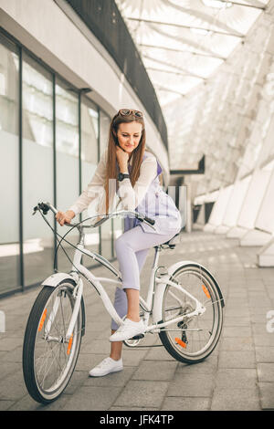 Tourné sur toute la longueur d'une belle jeune femme d'affaires avec son vélo Banque D'Images