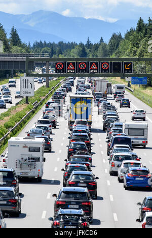 Les marchandises qui circulent sur l'autoroute 8 en direction de Salzbourg et l'autoroute du Brenner pendant qu'un écran qui pèsent sur l'autoroute met en garde contre le trafic dans la forêt près de Hofolding à Sauerlach, Allemagne, 01 juillet 2017. Il y a trafic lourd aujourd'hui à la Bavière depuis les vacances d'autoroutes a débuté ce week-end à trois états allemands. Les Alpes peut être vu dans l'arrière-plan. Photo : Matthias Balk/dpa Banque D'Images