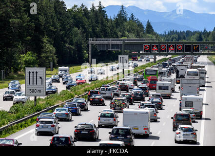 Les marchandises qui circulent sur l'autoroute 8 en direction de Salzbourg et l'autoroute du Brenner pendant qu'un écran qui pèsent sur l'autoroute met en garde contre le trafic dans la forêt près de Hofolding à Sauerlach, Allemagne, 01 juillet 2017. Il y a trafic lourd aujourd'hui à la Bavière depuis les vacances d'autoroutes a débuté ce week-end à trois états allemands. Les Alpes peut être vu dans l'arrière-plan. Photo : Matthias Balk/dpa Banque D'Images