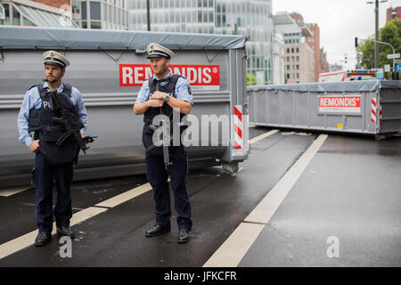 Düsseldorf, Allemagne. 1er juillet 2017. Les policiers avec des pistolets de la machine se tenir en face de conteneurs sur la voie à Duesseldorf, Allemagne, 1 juillet 2017. Le Tour de France commence à Düsseldorf et un à partir de la jambe, une circulaire cours de 14 kilomètres. Photo : Rolf Vennenbernd/dpa/Alamy Live News Banque D'Images