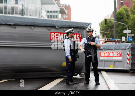 Düsseldorf, Allemagne. 1er juillet 2017. Les policiers avec des pistolets de la machine se tenir en face de conteneurs sur la voie à Duesseldorf, Allemagne, 1 juillet 2017. Le Tour de France commence à Düsseldorf et un à partir de la jambe, une circulaire cours de 14 kilomètres. Photo : Rolf Vennenbernd/dpa/Alamy Live News Banque D'Images