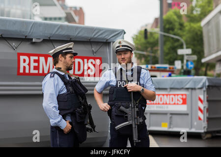 Düsseldorf, Allemagne. 1er juillet 2017. Les policiers avec des pistolets de la machine se tenir en face de conteneurs sur la voie à Duesseldorf, Allemagne, 1 juillet 2017. Le Tour de France commence à Düsseldorf et un à partir de la jambe, une circulaire cours de 14 kilomètres. Photo : Rolf Vennenbernd/dpa/Alamy Live News Banque D'Images