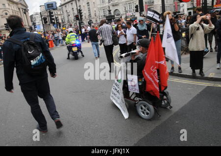 Un homme handicapé en fauteuil roulant va à John McDonnell Anti-Tory Mars à Londres. Banque D'Images