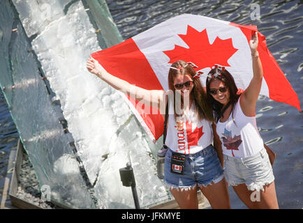 Vancouver, Canada. 1er juillet 2017. Deux femmes posent pour des photos avec un drapeau canadien au cours de la célébration de la fête du Canada à Canada Place à Vancouver, Canada, 1 juillet, 2017. Les gens se sont réunis à la Place du Canada dans le centre-ville de Vancouver pour célébrer le 150e anniversaire du Canada, le samedi. Credit : Liang sen/Xinhua/Alamy Live News Banque D'Images