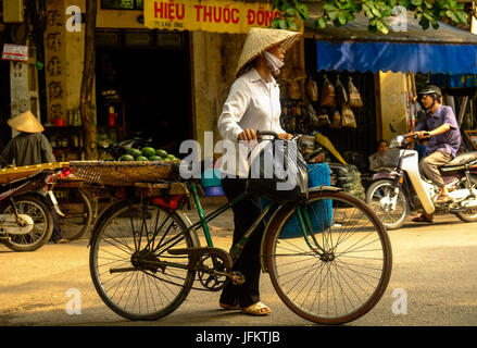 Les résidents, les vendeurs de rue et commerçants vaquaient à leurs activités quotidiennes dans le vieux quartier de Hanoi, Vietnam Banque D'Images