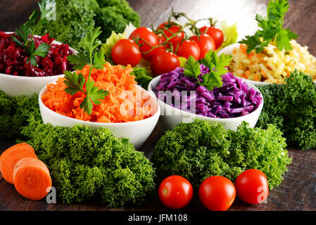 La composition avec quatre bols à salades de légumes sur la table en bois. Banque D'Images