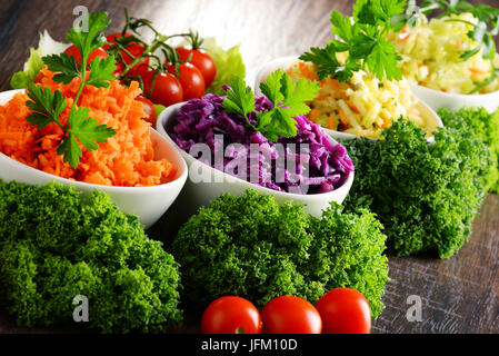 La composition avec quatre bols à salades de légumes sur la table en bois. Banque D'Images