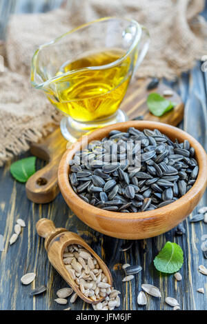 Bol de graines de tournesol et une tasse d'huile de tournesol. Banque D'Images