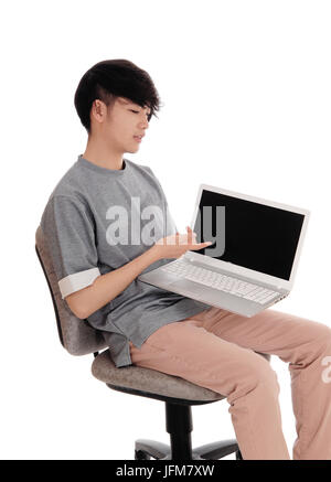 Adolescent asiatique pointant sur son ordinateur portable. Banque D'Images