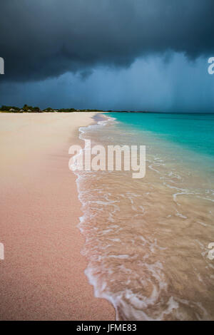Les nuages de tempête sur du sable fin encadré par les eaux turquoise de la plage de sable rose Antigua-et-Barbuda Antilles Îles sous le vent Banque D'Images