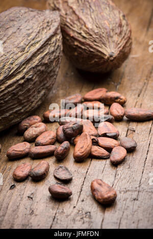 Les cabosses de cacao avec les fèves de cacao sur table en bois Banque D'Images