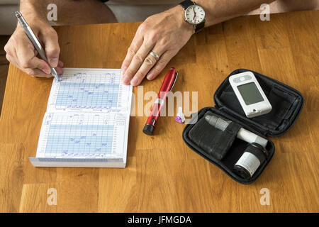 Prendre des notes diabétique dans son test de glycémie d'adresses, notes sur les niveaux de glucose de sang, journal, Banque D'Images