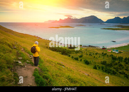 Vue panoramique vue aérienne de la mer au coucher du soleil. L'homme l'homme debout sur une montagne touristique et contemplant le coucher du soleil sur le fjord. Beau paysage de montagne Banque D'Images