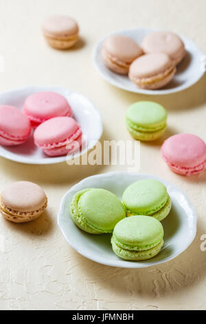Avec trois plaques de macarons à la rose, vert et marron Banque D'Images