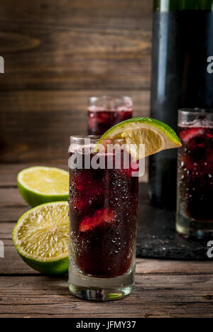 Boisson alcoolisée traditionnelle espagnole, cocktail, Calimocho. Avec le vin, cola, jus de lime et de la glace. Décoré avec des morceaux de citron vert. Copy space Banque D'Images