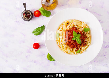 Bolognaise pâtes fettucine à la sauce tomate dans un bol blanc. Mise à plat. Vue d'en haut Banque D'Images