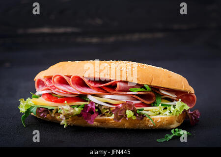 Big sandwich au jambon, salami, tomate, concombre et fines herbes Banque D'Images