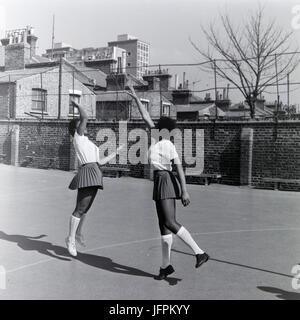 Deux jeunes filles noires, afro caraïbes jouer netball à Londres, en Angleterre, pendant les années 1970. Banque D'Images