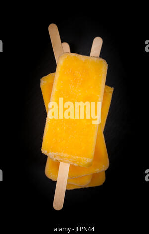 Ananas, abricot et Popsicles mangue sur fond noir Banque D'Images