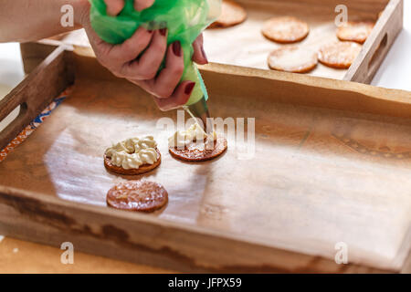 Chef pâtissier décoration d'un mille-feuille gâteau avec une crème fouettée Banque D'Images