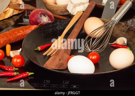 Poêle en acier sur la cuisinière. Des ustensiles de cuisine. Préparation de l'omelette d'oeufs. Alimentation nourriture Banque D'Images