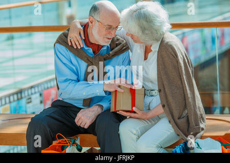 Senior couple in shopping mall with gifts Banque D'Images