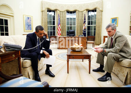 Le président Barack Obama parle par téléphone avec l'Arkansas Gouverneur Mike Beebe concernant les conditions météorologiques dans l'Arkansas, alors que Denis McDonough, directeur des communications stratégiques, le Conseil national de sécurité, le CNS est assis avec lui dans le bureau ovale 1/28/09. Photo Officiel de la Maison Blanche par Pete Souza Banque D'Images