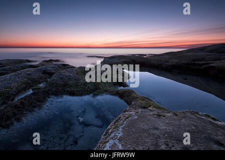 Seascape pendant le lever du soleil. Beau paysage marin naturel, l'heure bleue. Rocky le lever du soleil. Lever du soleil sur la mer à la côte de la mer Noire près de Ravda. Banque D'Images