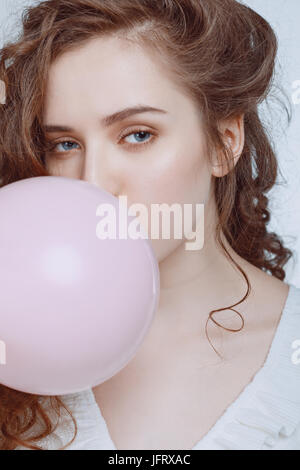 Portrait de jeune hipster girl blowing bubble gum isolated on white Banque D'Images