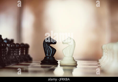 Pièces des échecs chevaliers en face de l'autre pour une impasse. des chevaux qui s'affrontent. Chevaliers d'échecs tête-à-tête. Banque D'Images