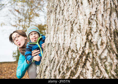 La mère et le fils héritier coller dehors à la recherche de salons à grand arbre à décor de l'automne