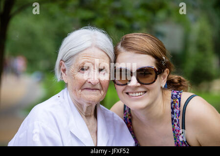 Petite-fille adultes et grand-mère senior smiling in summer park Banque D'Images