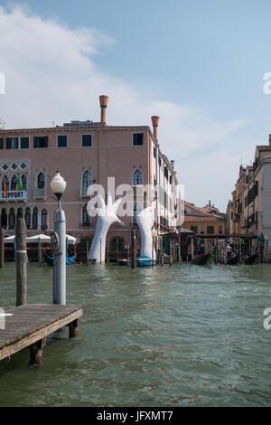 L'appui, une sulpture situé sur le côté de l'hôtel Ca' Sagredo à Venise, en Italie, par l'artiste Lorenzo Quinn Banque D'Images