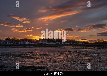 Vue paysage sur la baie de Garlieston village avec la marée et un coucher du soleil doré derrière. Banque D'Images