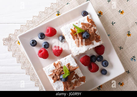 Morceaux de gâteau au chocolat aux fruits rouges sur une plaque horizontale vue du dessus. Banque D'Images