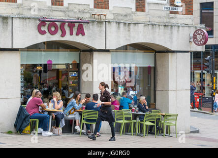 Les gens assis à l'extérieur d'un café Costa ayant une pause-café. Banque D'Images