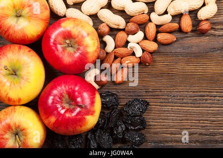 Le rouge des pommes mûres, amandes et arachides, sur un fond de bois. Vue d'en haut Banque D'Images