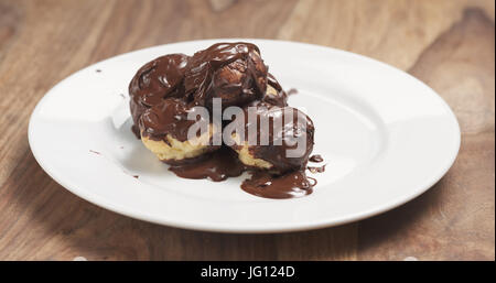 Profiteroles au chocolat noir fin sur la plaque, large photo Banque D'Images