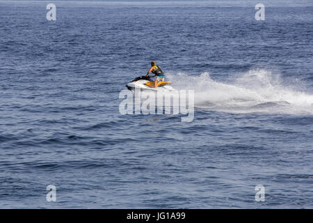 Le jeune homme équitation jet ski en mer bleu Banque D'Images