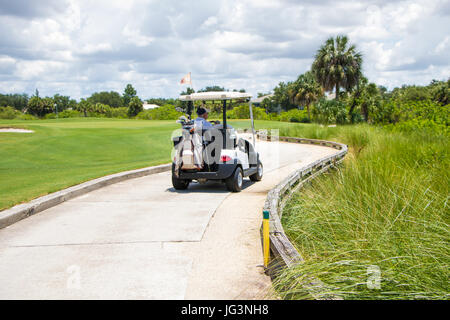 La conduite de l'homme sur le chemin de chariot de golf Banque D'Images