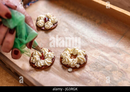 Woman decorating mille-feuille cake avec de la confiture Banque D'Images