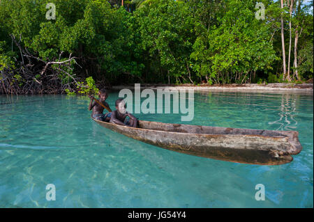 Les jeunes garçons assis dans un canot, lagon de Marovo, Îles Salomon, Pacifique Banque D'Images