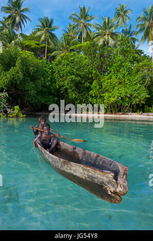 Les jeunes garçons assis dans un canot, lagon de Marovo, Îles Salomon, Pacifique Banque D'Images