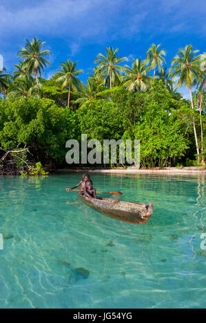 Les jeunes garçons assis dans un canot, lagon de Marovo, Îles Salomon, Pacifique Banque D'Images