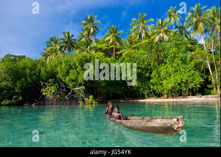 Les jeunes garçons assis dans un canot, lagon de Marovo, Îles Salomon, Pacifique Banque D'Images