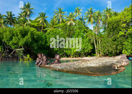 Les jeunes garçons assis dans un canot, lagon de Marovo, Îles Salomon, Pacifique Banque D'Images