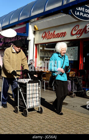 L'homme et la femme à la lumière du jour à l'extérieur de marche retraités un café à Witham Banque D'Images