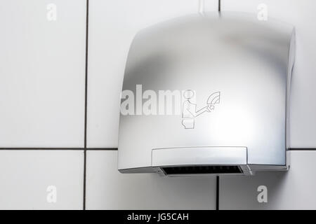 Le sèche-mains mural carrelage blanc dans la salle de repos Banque D'Images