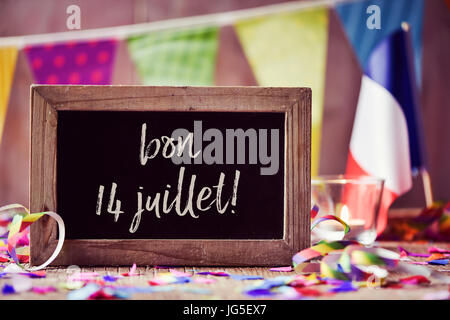 Tableau sur le texte bon 14 juillet, 14 juillet, la Journée nationale de la France, écrit en français et d'un pavillon de la France, sur une surface en bois sprink Banque D'Images